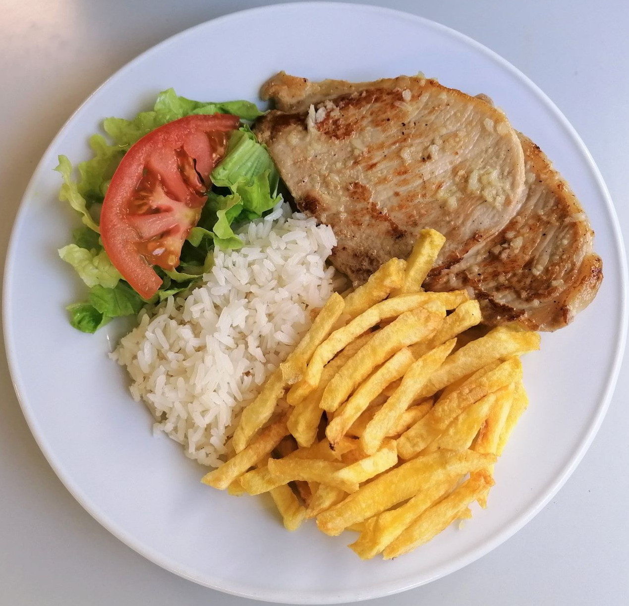 Escalopes de porco ao alho com arroz e batata frita