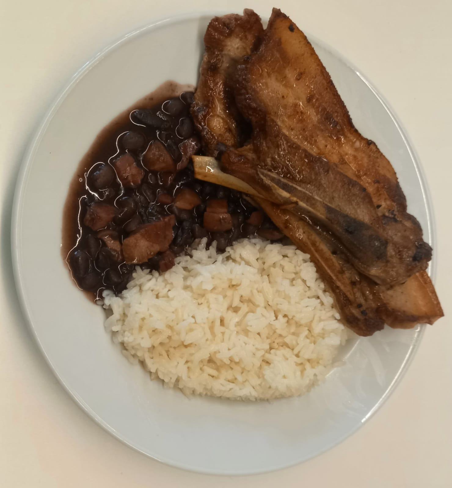 Entrecosto de porco grelhado com arroz branco e feijão preto (com bacon)